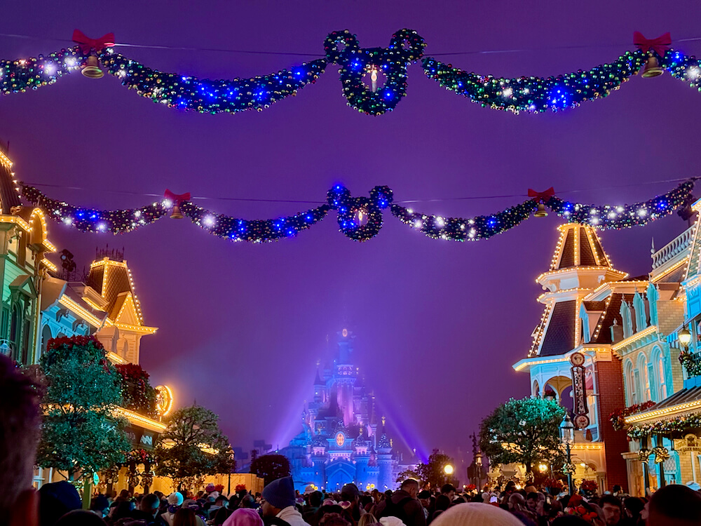 Castillo de Disneyland Paris de noche con la decoración de navidad